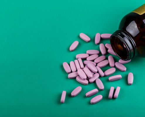 View of coated tablets spilled out of a medicine bottle