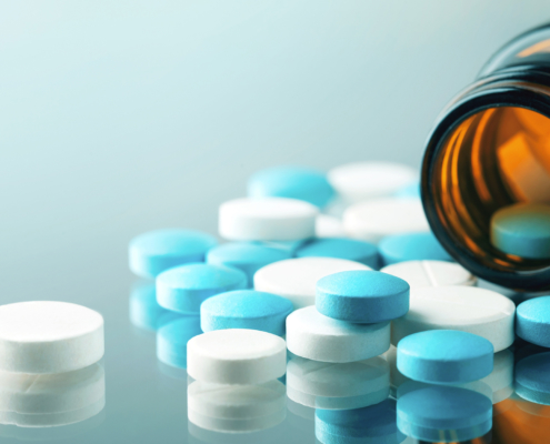 View of uncoated tablets falling out of a medicine bottle