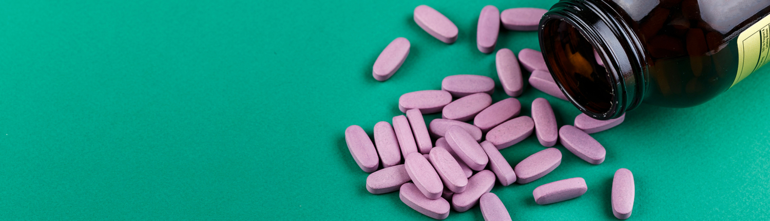 View of coated tablets spilled out of a medicine bottle